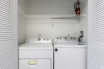 an empty laundry room with two washes and a dryer